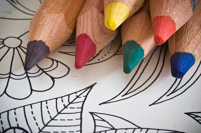 A black and white coloring page with colored pencils sitting on top.